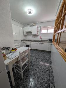 eine Küche mit weißen Schränken und einem weißen Tisch in der Unterkunft Casa Cimalavilla CABORNERA in Cabornera + 17 Fotos