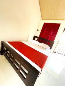 a bedroom with a bed with a red blanket at Stay Lanka Guest House in Nikawatawana