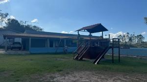 une aire de jeux en face d'une maison dans l'établissement Chácara Fazendinha Oliveira, à Mogi das Cruzes