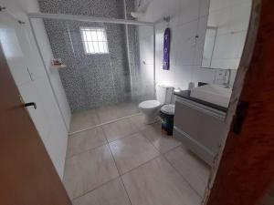 une petite salle de bain avec toilettes et lavabo dans l'établissement Chácara Fazendinha Oliveira, à Mogi das Cruzes 5 autres photos