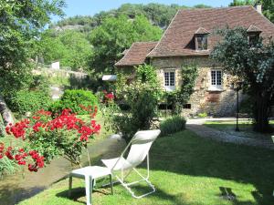 een witte stoel in het gras voor een huis bij Le Moulin De La Beune in Les Eyzies-de-Tayac