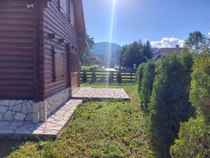 a house with a stone walkway next to a building at Zara Chalet in Kolašin