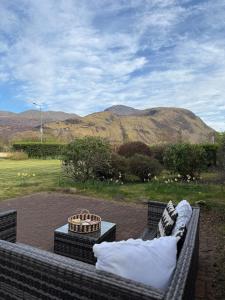 a couch sitting on a patio with a view of a mountain at Firdale in Fort William