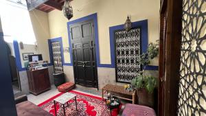 a room with two black doors and a red rug at Riad Mamma MARRAKESH in Marrakech