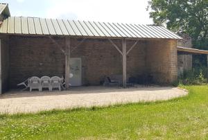 a brick building with tables and chairs in it at Gîte Le BB in Chenay