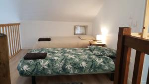 a bedroom with a bed with a green bedspread at Gîte Le BB in Chenay