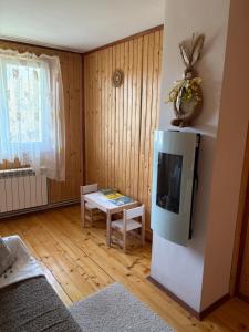 Una sala de estar con un televisor y una mesa. en Басейн з підігрівом! Batkivska Svitlitsa NEW Без господарів, en Slavske