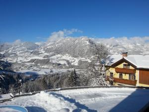 a house in the snow with a view of a mountain at Haus Oberstocker in Sankt Johann im Pongau