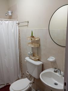 a bathroom with a toilet and a sink and a mirror at Casa Daia con cochera y piscina in Resistencia
