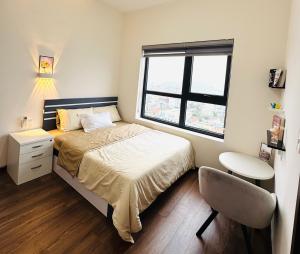 a bedroom with a bed and a desk and a window at Homestay Phuong Thao Luxcity Cam Pha in Hòn Một