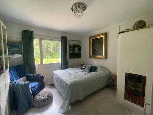 a bedroom with a bed and a chair and a window at Villa Kurenniemi in Taipalsaari
