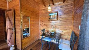 a room with a wooden wall with a table and chairs at Mahanaim Casa De Campo in Caaguazú