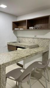 a kitchen with a marble counter and a chair at Apto 515 - Seu Refúgio na Praia - Nobile Hotel in João Pessoa