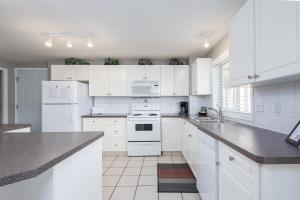 a white kitchen with white appliances and white cabinets at Paradise Canyon Golf Resort - Signature Walkout Condo 380 in Lethbridge