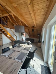 a dining room with a wooden table and chairs at 5-Seen-Loft mit 4-6 Schlafplätzen, Ferienwohnung Nähe Ammersee in Kottgeisering