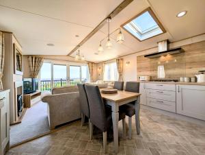 a kitchen and living room with a table and a couch at Luxury Lodge With Stunning Full Sea Views At Hopton Ref 80010W in Great Yarmouth