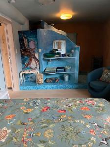 a living room with a blue rug and a mirror at Kamer in een Strobalen huis in Linter