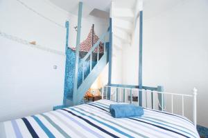 a bedroom with a blue and white striped bed at Milin Avel I 6 personnes & plage in Crozon