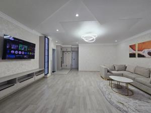 Una sala de estar con un sofá y un televisor de pantalla plana. en Modern comfort appartment, en Salor Bekati