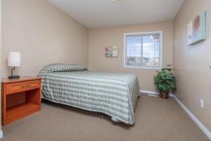 une chambre avec un lit, une table et une fenêtre dans l'établissement Paradise Canyon Golf Resort - Luxury Condo U403, à Lethbridge