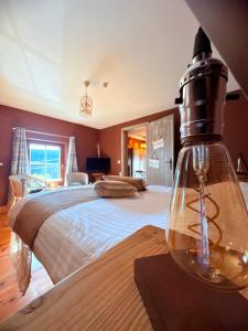 a bedroom with a bed and a bottle on a table at Comme à la Ferme in Durbuy