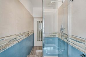 a bathroom with a glass shower and blue walls at Souvenir, Terre Marine in La Spezia +6 photos