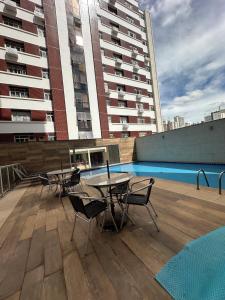 a patio with tables and chairs on top of a building at Magnífico - Apartamento Completo in Brasilia