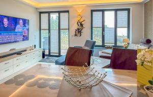 ein Wohnzimmer mit Tisch und Fernseher in der Unterkunft Eden in Binz