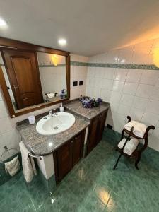 a bathroom with a sink and a mirror and a chair at L'attico di Giorgio in Samatzai +48 photos