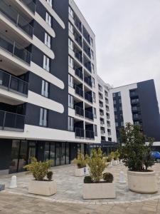 a large building with potted trees in front of it at Ribica Apartments in Ilidža