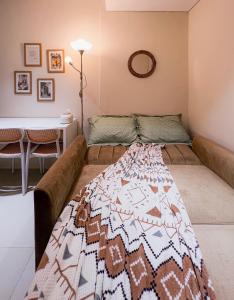 eine Couch in einem Wohnzimmer mit einer Decke drauf in der Unterkunft Madison Park Apartments by Host Jess in Jakarta