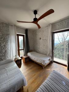 a bedroom with two beds and a ceiling fan at Sea View - Private House with Garden in Pisciotta in Caprioli
