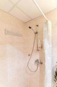 a shower with a shower head in a bathroom at Your city apartment. in Tallinn +23 photos