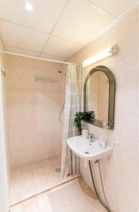 a bathroom with a sink and a shower with a mirror at Your city apartment. in Tallinn
