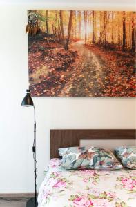 a bedroom with a bed and a painting of a forest at Your city apartment. in Tallinn