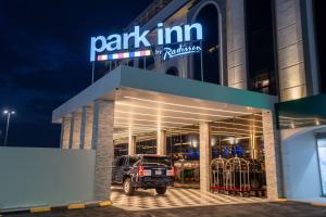 a parking lot in front of a park inn of rotation at night at Park Inn by Radisson Najran in Najran