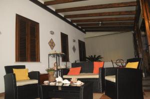 a living room with chairs and a table with colorful pillows at Kimos in San Vito lo Capo