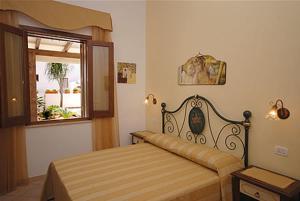 a bedroom with a bed and a window at Kimos in San Vito lo Capo