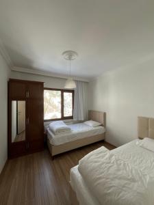 ein Schlafzimmer mit zwei Betten und einem Fenster in der Unterkunft Defne Apart in Çamlıhemşin