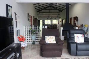 a living room with two chairs and a television at Alojamiento campestre CASA GRANDE Guateque Hospedaje in Guateque