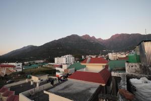 Una vista de una ciudad con montañas al fondo. en Hotel Neelkanth Katra, en Katra