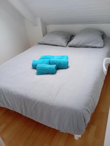 two blue pillows sitting on top of a bed at Charmant appartement Saint-Malo in Saint Malo