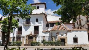 a white house with a white fence and trees at El Escondite de Aragón in Mora de Rubielos