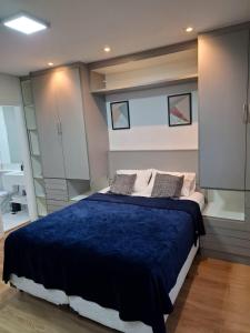 a bedroom with a large bed with a blue blanket at Studio premium próximo a Alphaville in Barueri +19 photos