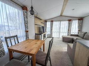 a living room with a table and a couch at Beautiful Caravan With Decking At Azure Seas In Suffolk, Sleeps 6 Ref 32004Az in Lowestoft
