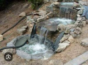 a waterfall in a rock pool with a water hose at Casa fin de semana in Temixco
