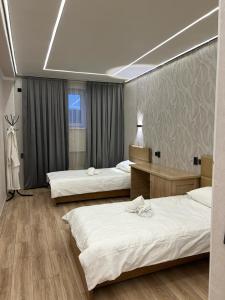 a hotel room with three beds and a window at Достук in Karachiy