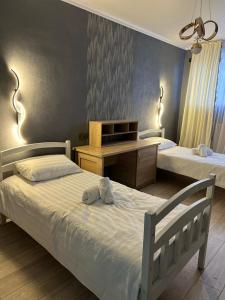 a bedroom with two twin beds and a desk at Достук in Karachiy
