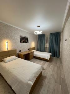 a hotel room with two beds and a desk at Достук in Karachiy