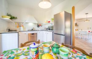 a kitchen with a table and a refrigerator at Lovely Home In Piane Vecchie,Lascari in Lascari
